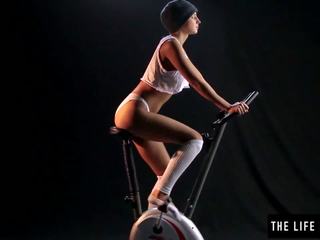 Cudowne sweaty nastolatka skakanie na exercise bike siedziba.